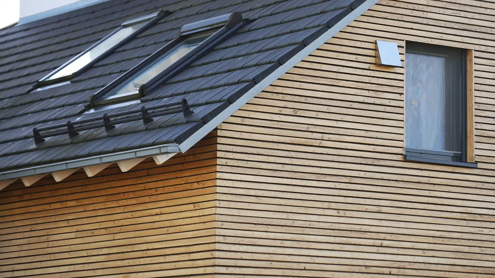 Maison moderne avec toiture en ardoise et façade en bois bois rénovée - Expertise Le Meilleur Service.